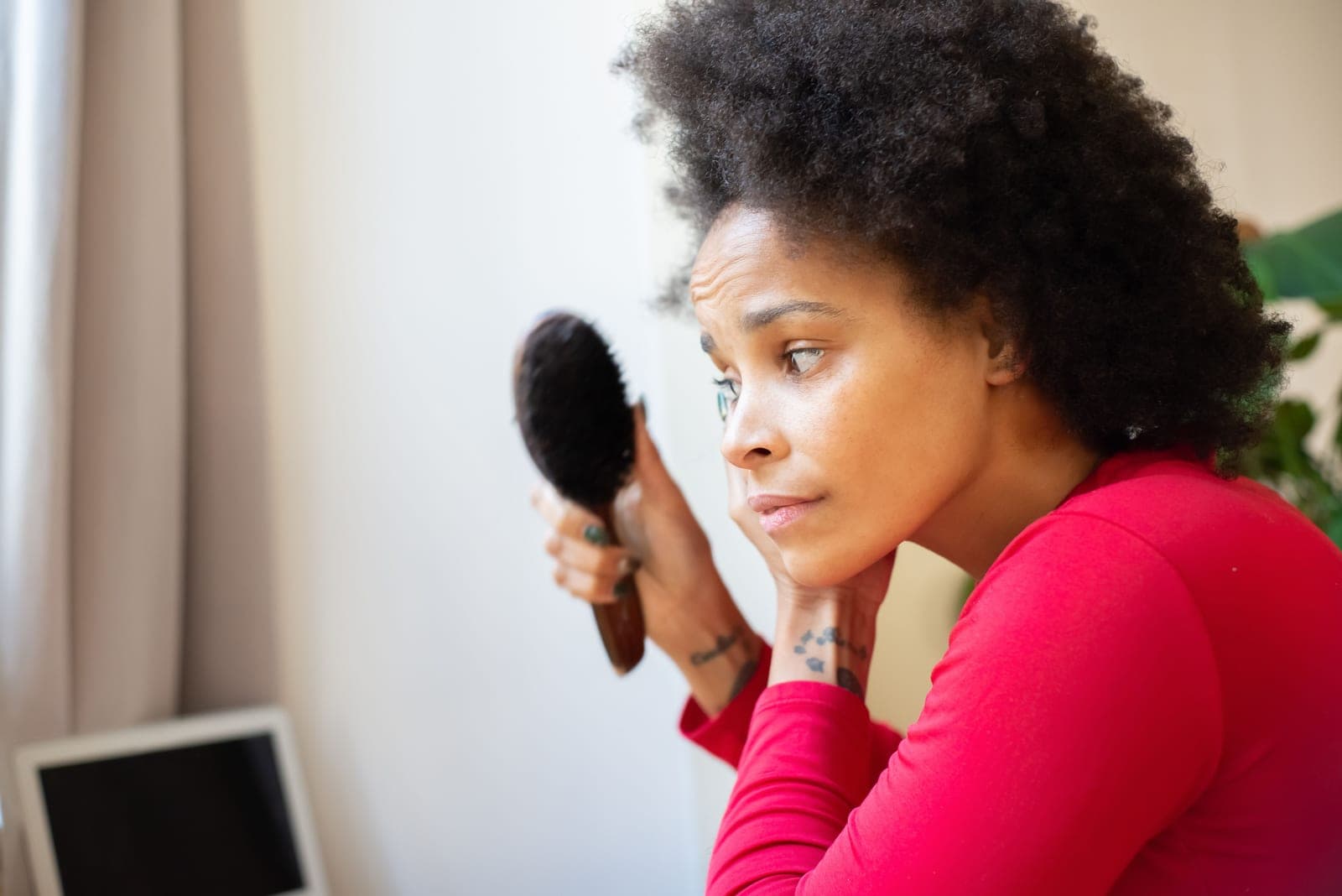 Coily natural hair being brushed and styled