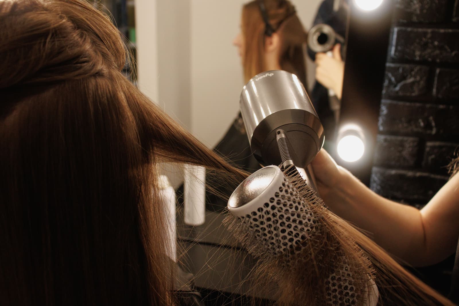 Fine hair being styled with a blow dry brush for volume