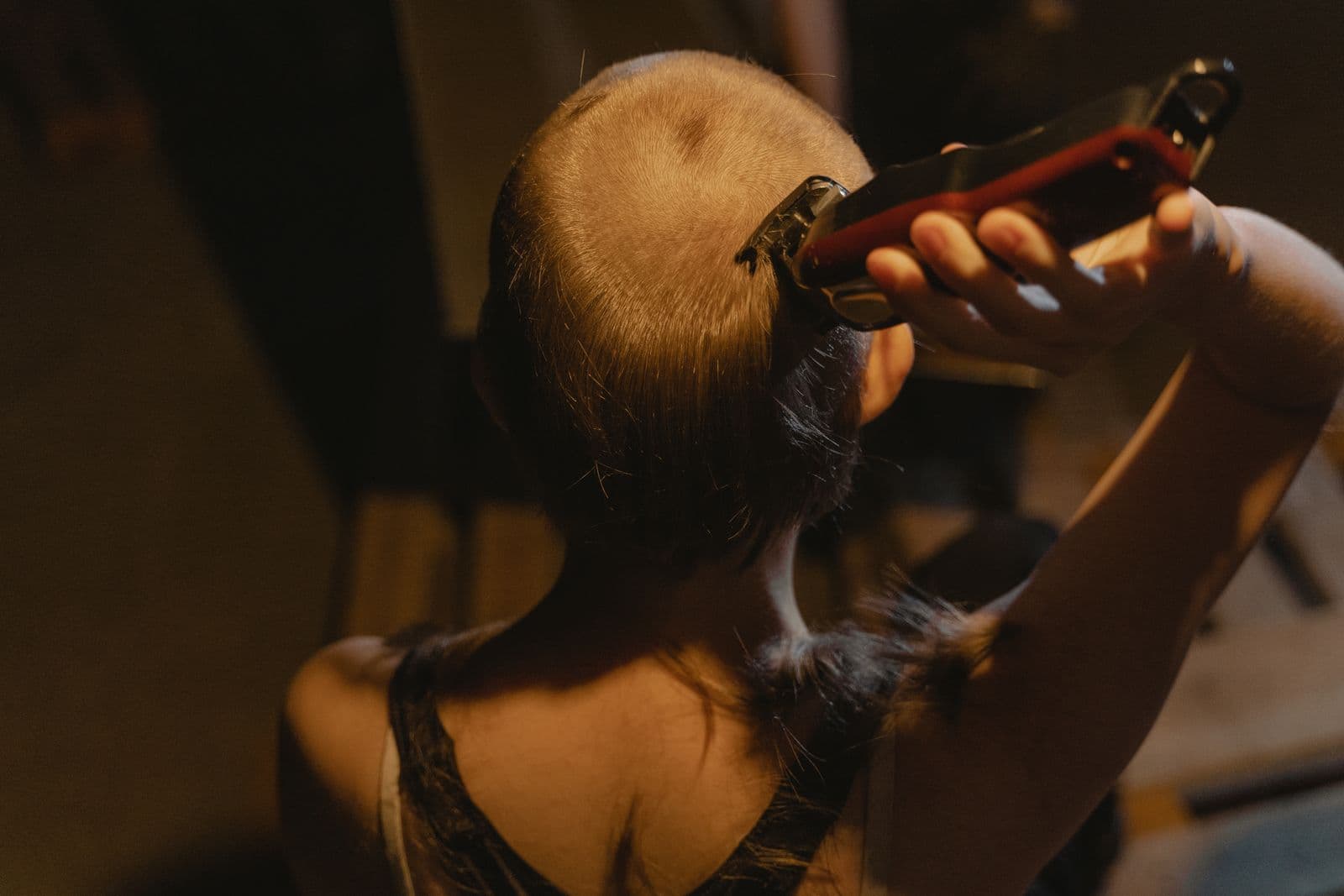 A man shaving his head with an electric shaver