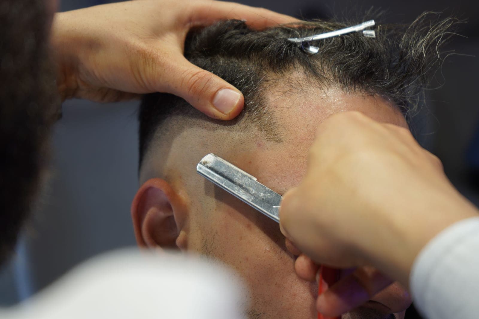 A barber fading hair with clippers