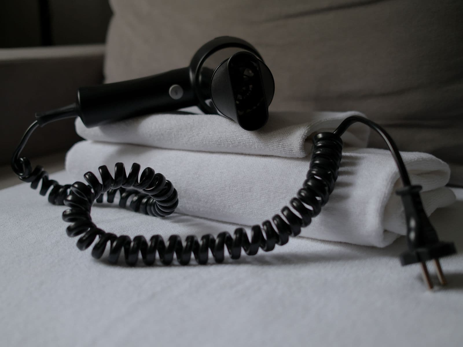 A hair dryer resting on folded white towels