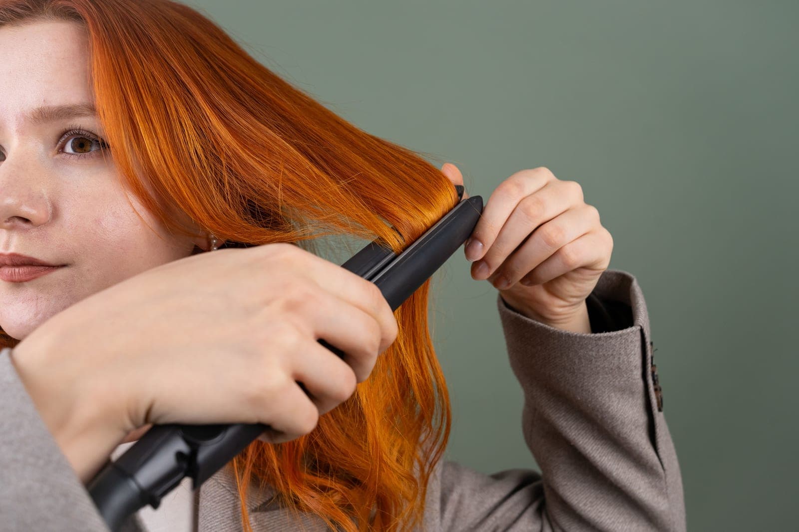 Curly hair being straightened with a flat iron