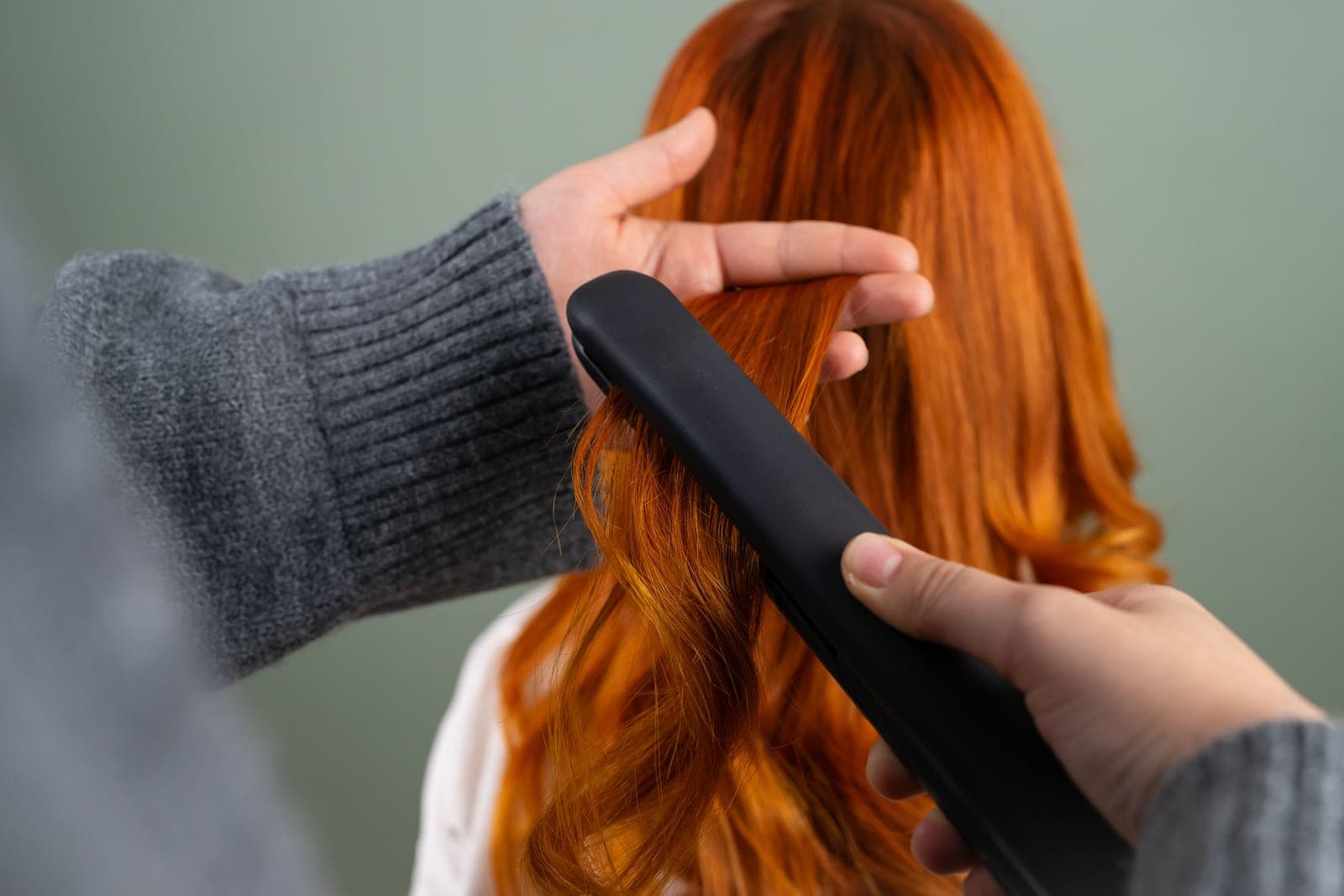 A flat iron straightening long fine hair