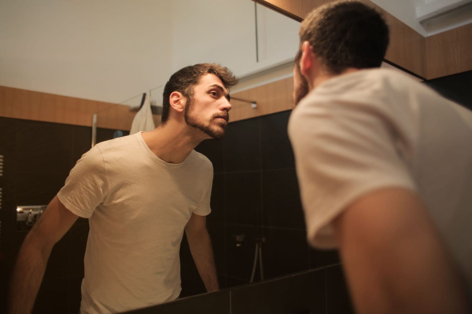A man styling short hair at a mirror