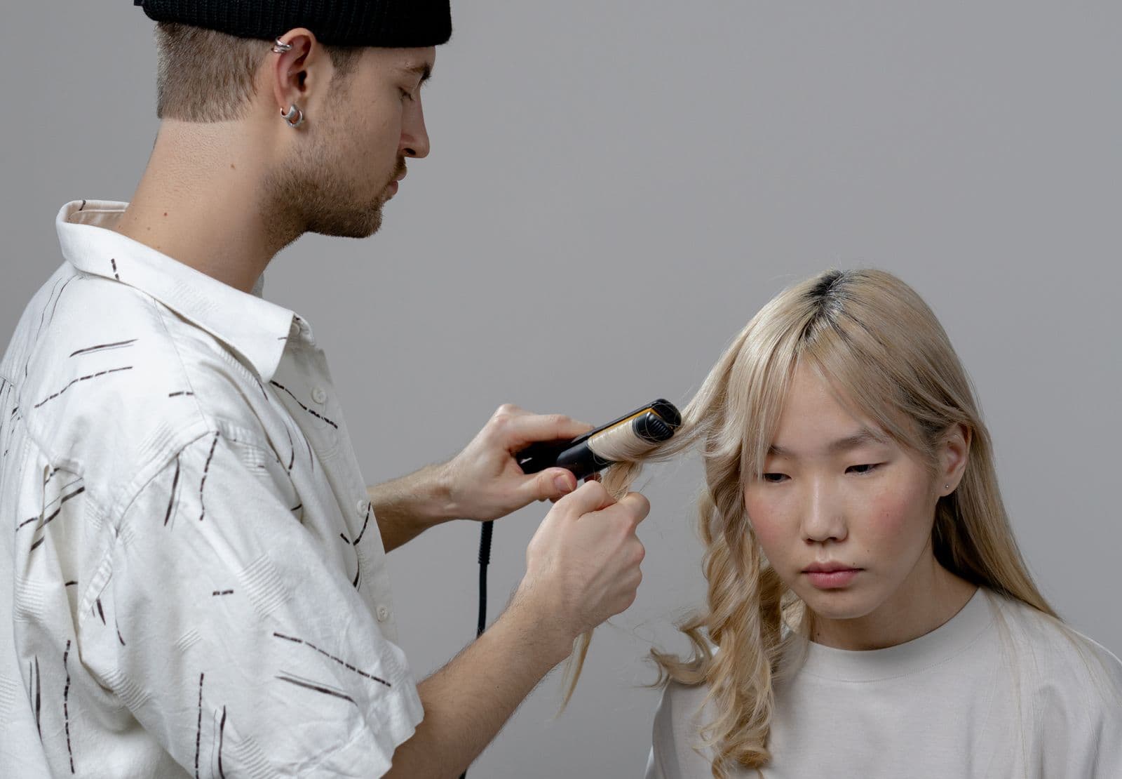 A stylist working with a flat iron in a salon